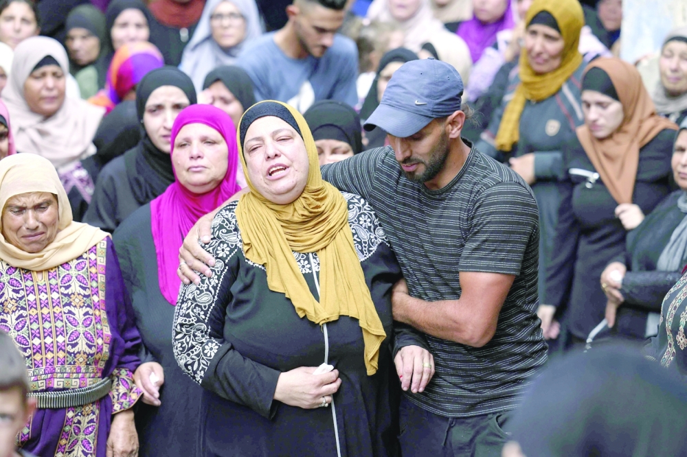 The mother of Palestinian Mahdi Mohammed Ladado, one of two Palestinians reportedly killed earlier as Israeli forces carried out an arrest operation in Jenin, is comforted by relatives during his funeral in the village of Al Mazraa Al Gharbia, near the occupied West Bank city of Ramallah. - AFP