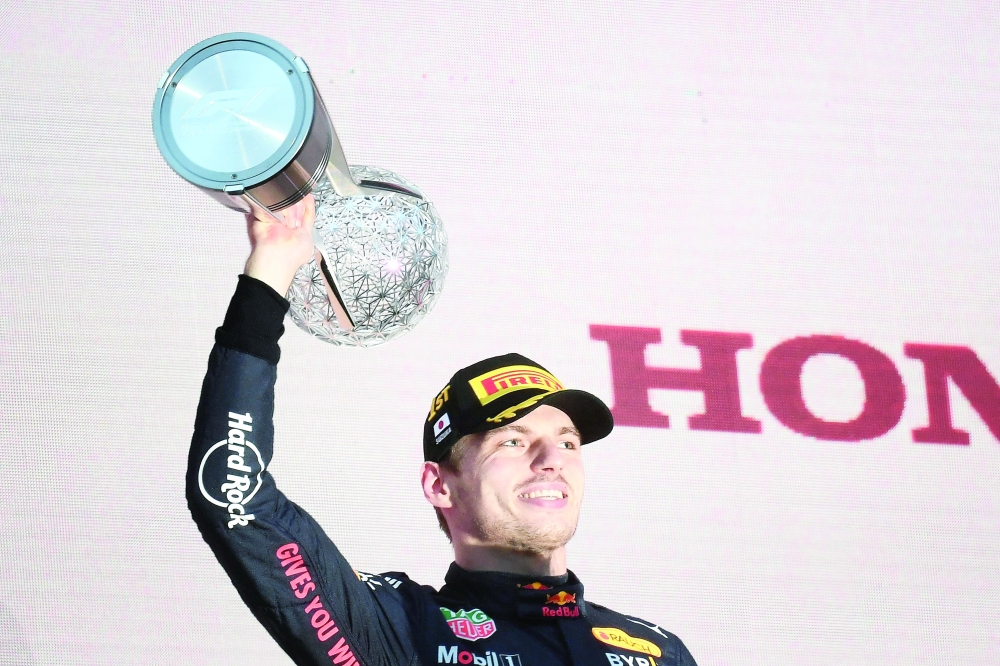 TOPSHOT - Red Bull Racing's Dutch driver Max Verstappen poses on the podium with the trophy following his victory at the Formula One Japanese Grand Prix at Suzuka, Mie prefecture on October 9, 2022. (Photo by Toshifumi KITAMURA / AFP)

