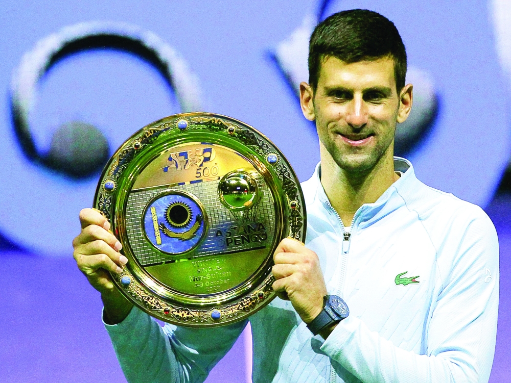Serbia's Novak Djokovic celebrates with the trophy after defeating Greece's Stefanos Tsitsipas in their men's singles final match at the Astana Open tennis tournament in Astana on October 9, 2022.  (Photo by AFP)


