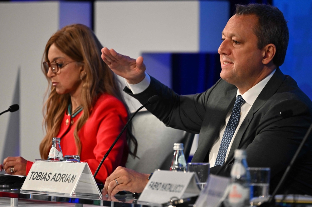 International Monetary Fund's Tobias Adrian (R), the financial-economic counselor and director of the Monetary and Capital Markets Department speaks during an event at the IMF headquarters in Washington, DC, on October 11, 2022. 