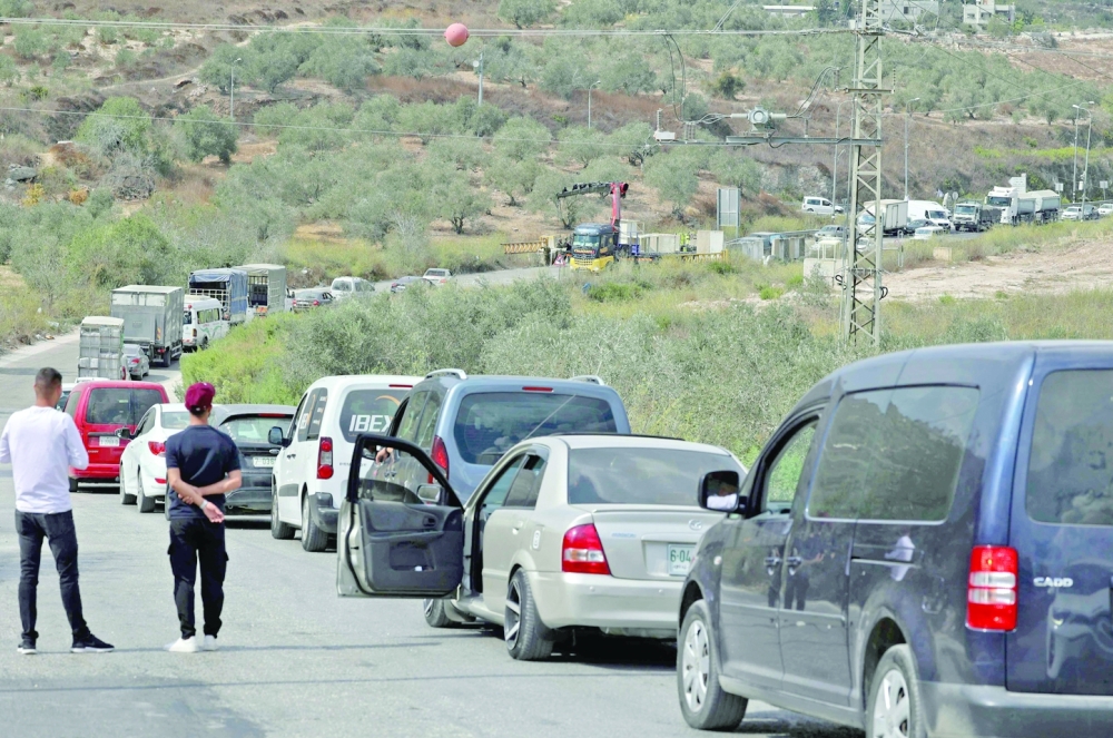 Cars line up as Palestinians try to enter the West Bank city of Nablus, through a checkpoint manned by Israeli security forces, on Thursday. -- AFP