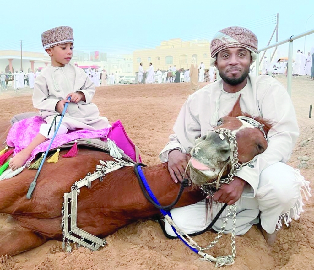 Rashid Salim Rashid Al Abrawi at the Barka horse farm with his son.