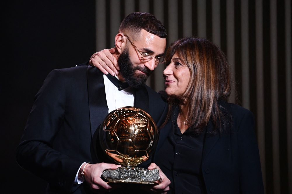 Real Madrid's French forward Karim Benzema (L) receives the Ballon d'Or award next to his mother Malika Benzema