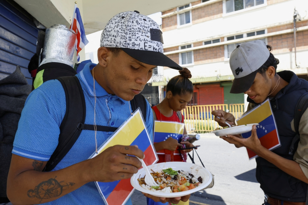Venezuelan migrants eat food provided by volunteers before they continue on their journey to the United States, in San Jose, Costa Rica October 18, 2022. REUTERS/Mayela Lopez

