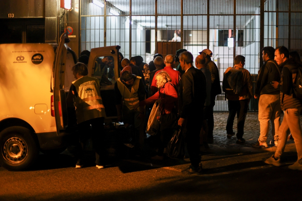 People wait in line to collect food from homeless charity CASA in central Lisbon, Portugal October 11, 2022. 