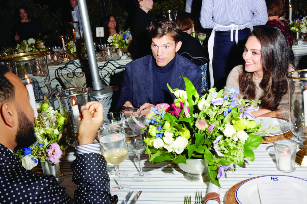 John Legend with Ashton Kutcher and Mila Kunis at the candlelit dinner at the Ralph Lauren spring 2023 fashion show in San Marino, Calif., Oct. 13, 2022. (Maggie Shannon/The New York Times)