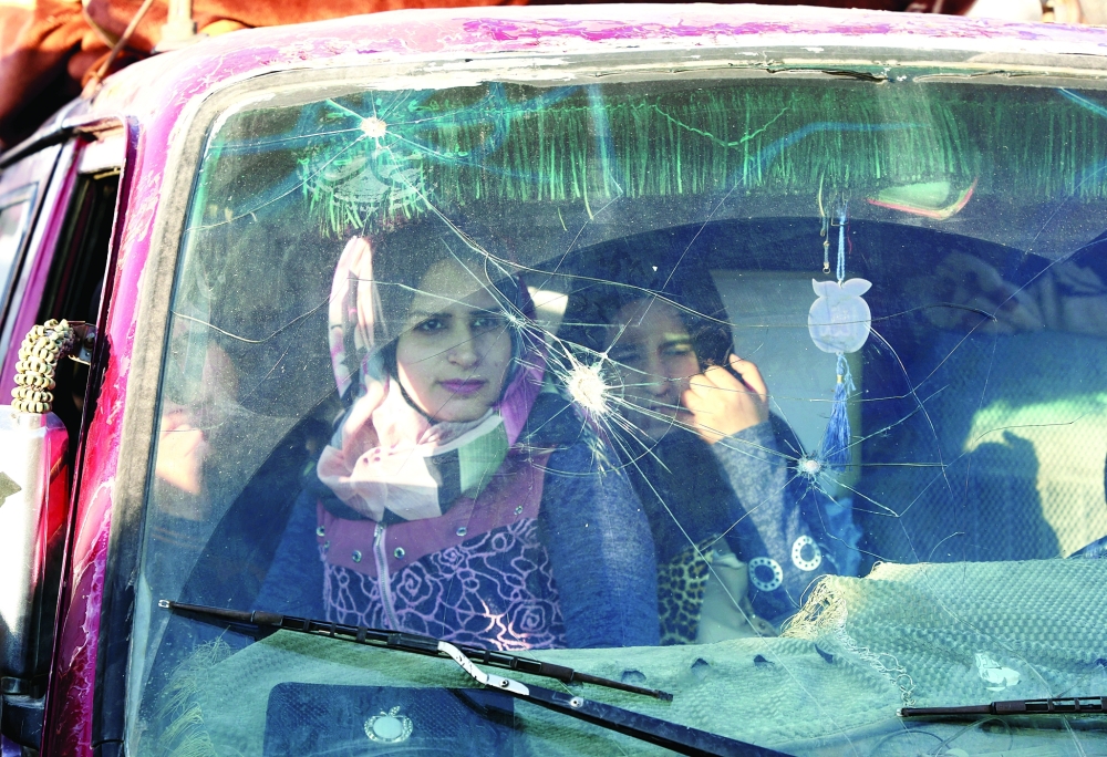Syrian refugees sit inside a vehicle as they prepare to return to Syria from Wadi Hmayyed. -- Reuters
