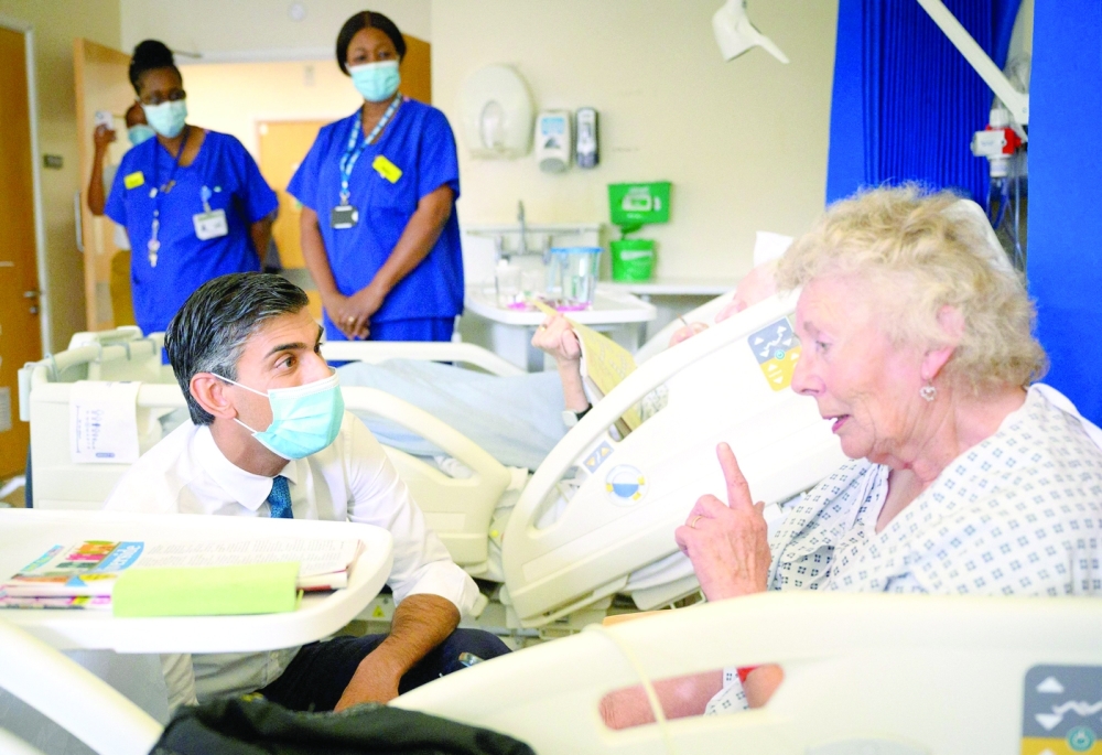 Britain's Prime Minister Rishi Sunak speaks with patient Catherine Poole during his visit to Croydon University Hospital in south London. -- AFP

