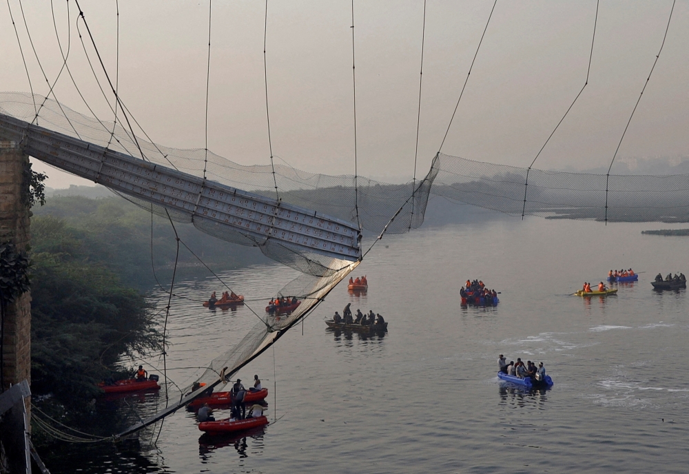 Rescuers search for survivors after a suspension bridge collapsed in Morbi town in the western state of Gujarat, India, October 31, 2022. 