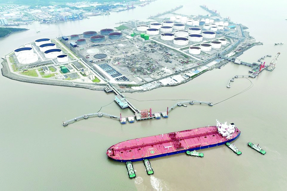 An aerial view shows tugboats helping a crude oil tanker to berth at an oil terminal, off Waidiao Island in Zhoushan, Zhejiang province, China. — Reuters