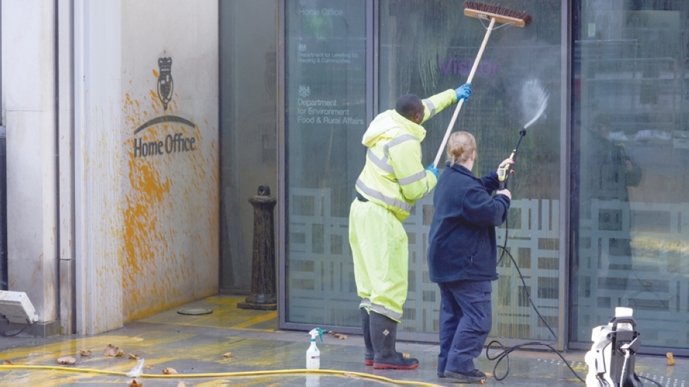 Climate activists spraypaint buildings orange Oman Observer