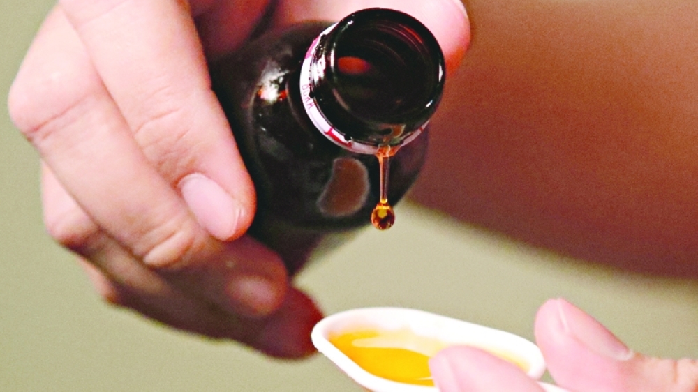 A cough medication is poured in this picture illustration