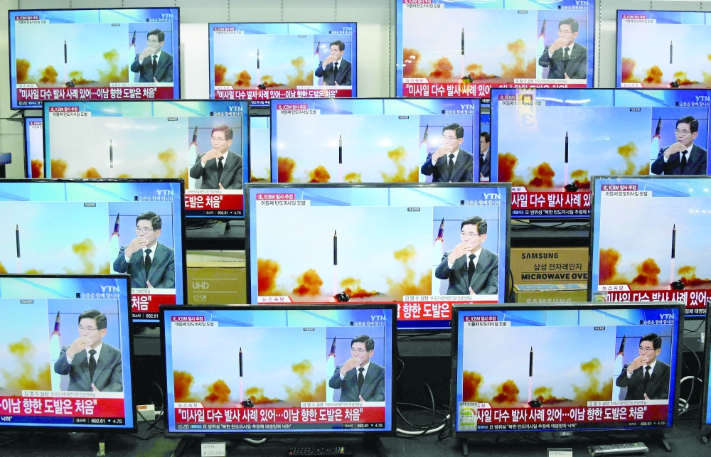 Television screens show a news report about the latest North Korean missile launch in Seoul. -- AFP