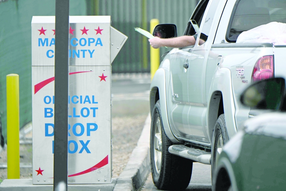 A voter puts a ballot into a ballot drop box for early voting outside of the Maricopa County Tabulation and Election Center ahead of the Arizona midterm elections in Phoenix. -- AFP