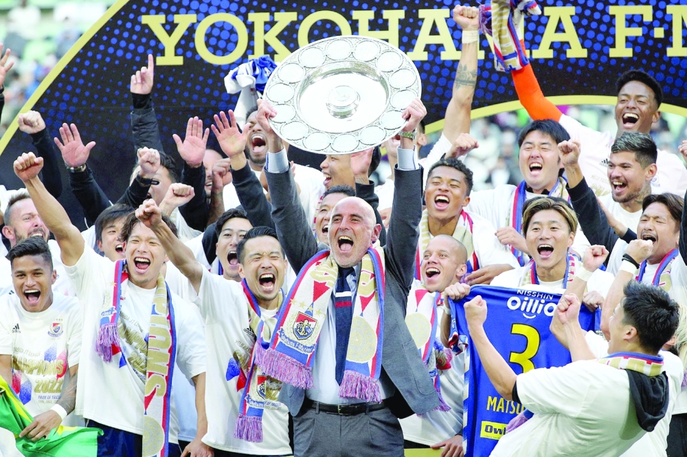 Yokohama F Marinos manager Kevin Muscat (C) holds up the trophy as he celebrates with team-mates after taking Japan's professional J-League football title following their 3-1 victory over Vissel Kobe to put them at the top of the standings, in Kobe on November 5, 2022.  - Japan OUT
 (Photo by JIJI PRESS / AFP)