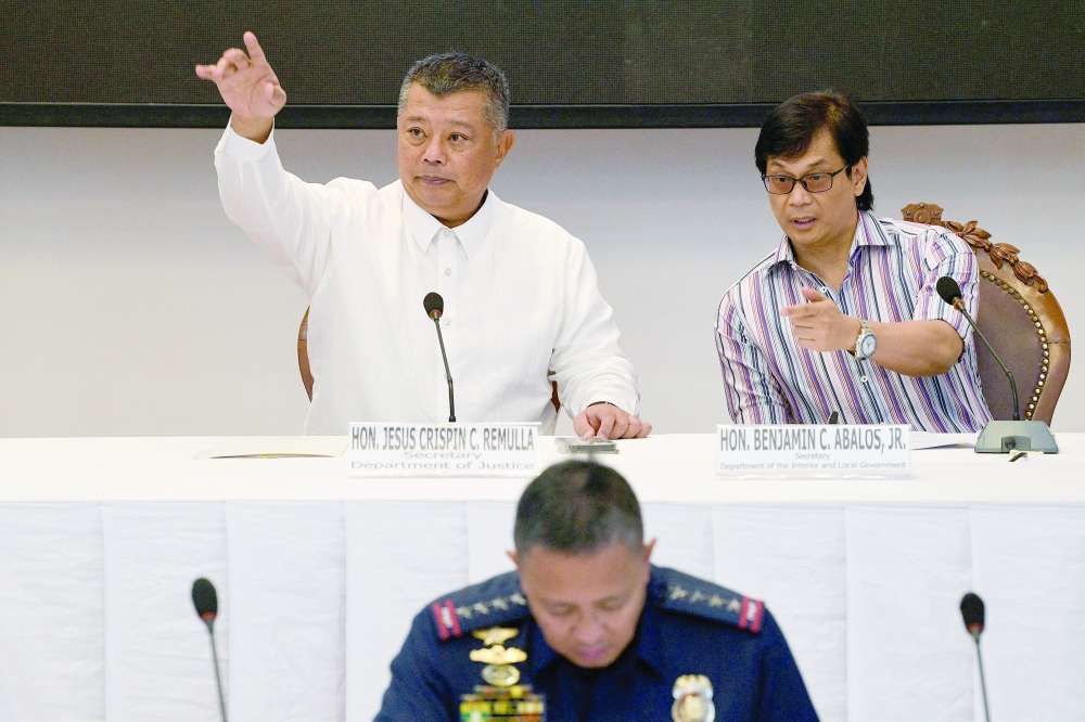Philippines' Secretary of Interior Benjamin Abalos Jr, (R) gestures with Justice Secretary Jesus Remulla (L) during a press conference announcing suspects in the killing of radio journalist Percival Mabasa, at the Department of Justice in Manila on Monday. -- AFP