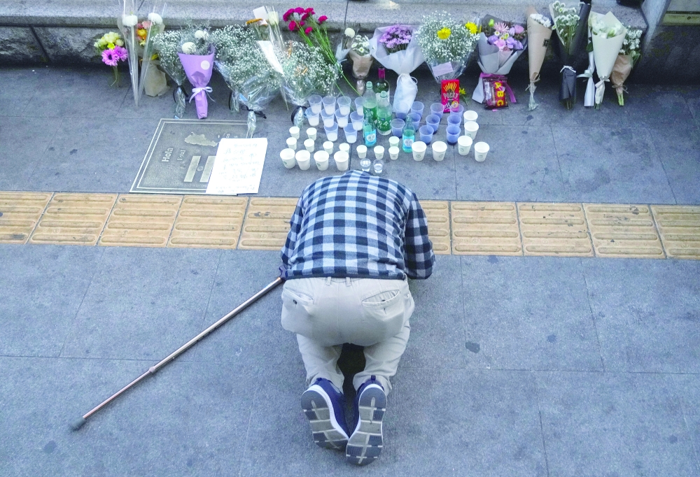 A mourner visits a memorial for the victims of Saturdays crowd surge that killed more than 150 people during a Halloween celebration, in the Itaewon neighborhood of Seoul on Oct. 30, 2022.