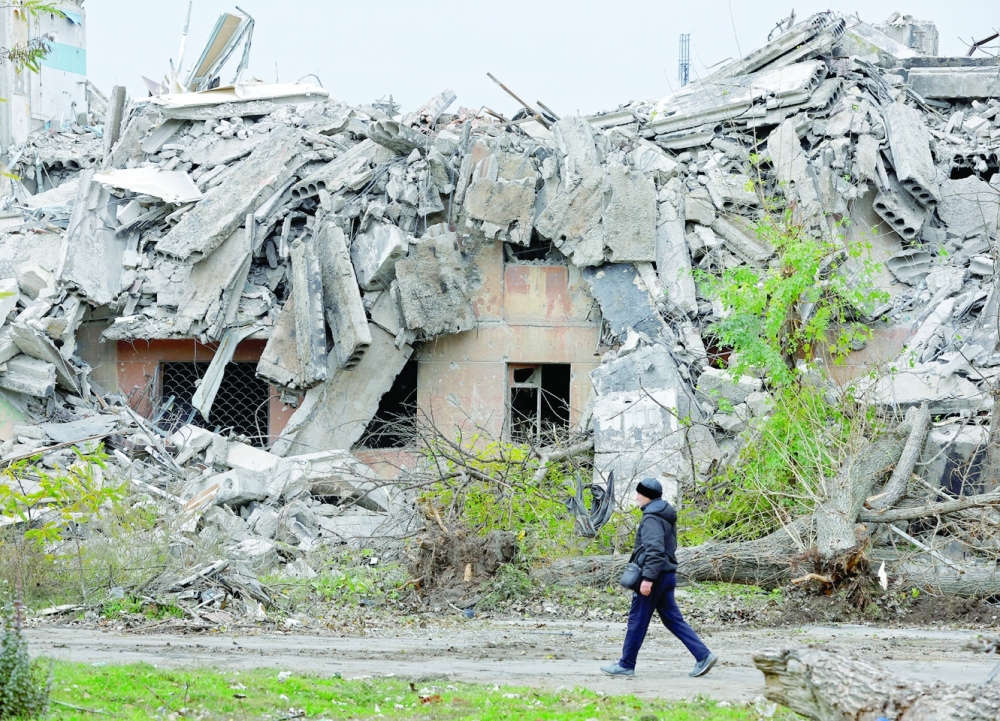 A man walks past the ruins of a building destroyed in Mariupol, Russian-controlled Ukraine. -- Reuters
