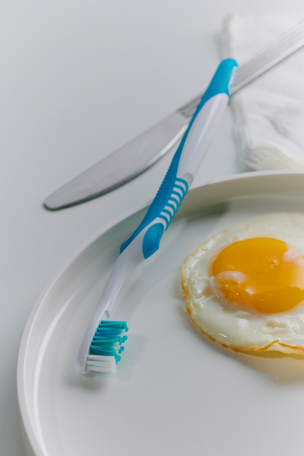 A photo illustration of a toothbrush, instead of a fork, beside a breakfast plate, in New York, Oct. 7, 2022. (Aileen Son/The New York Times)