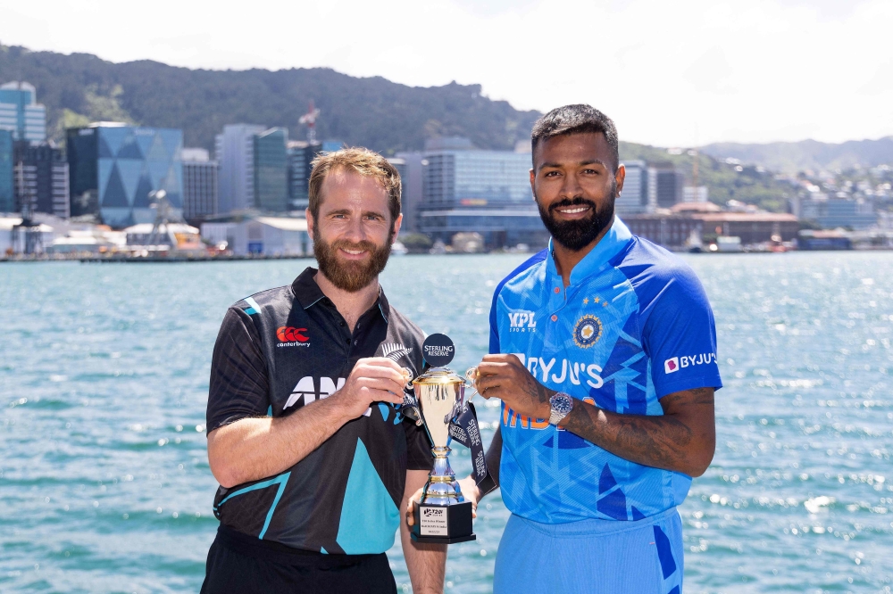 New Zealand captain Kane Williamson (L) and India captain Hardik Pandya (R) pose with the T20 trophy two days out from the first T20 match during a standup on the Water Front in Wellington on November 16, 2022. (Photo by Marty MELVILLE / AFP)

