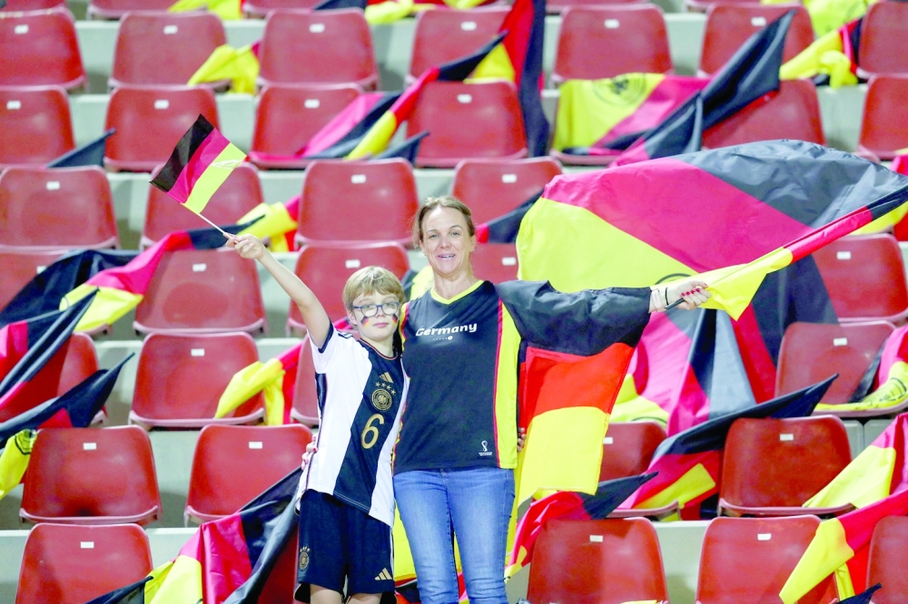 Germany's supporters lift flags in the stands ahead of a friendly football match between Oman and Germany at the Sultan Qaboos Sports Complex stadium in Muscat on November 16, 2022. (Photo by Haitham AL-SHUKAIRI / AFP)


