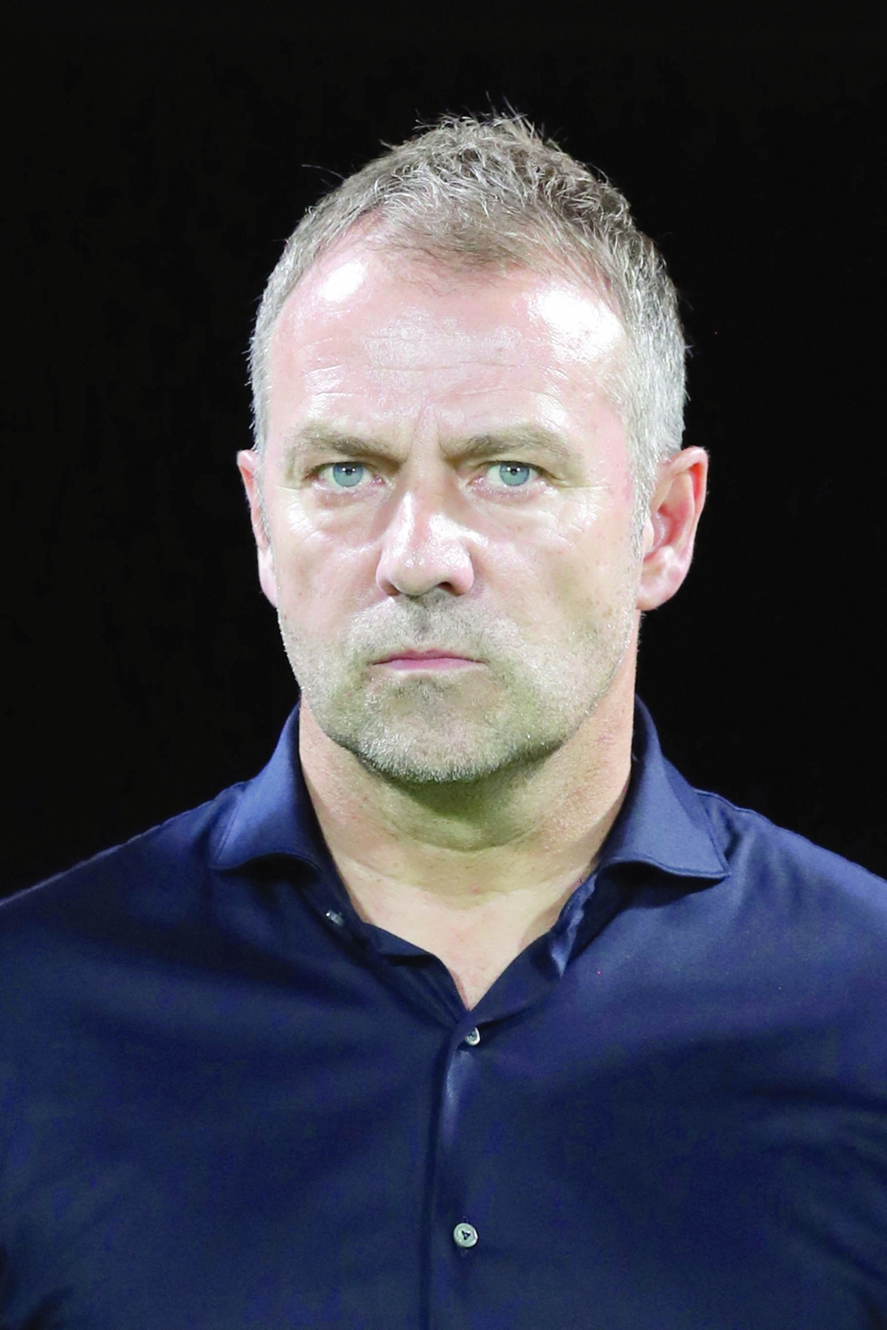 Germany's national football team head coach Hansi Flick stands for the national anthem ahead of a friendly football match between Oman and Germany at the Sultan Qaboos Sports Complex stadium in Muscat on November 16, 2022. (Photo by Haitham AL-SHUKAIRI / AFP)

