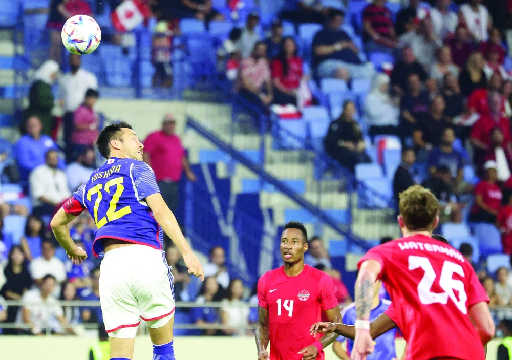 Japan's defender Maya Yoshida (L) head the ball during the friendly football match between Canada and Japan at Al-Maktoum Stadium in Dubai on November 17, 2022. (Photo by KARIM SAHIB / AFP)

