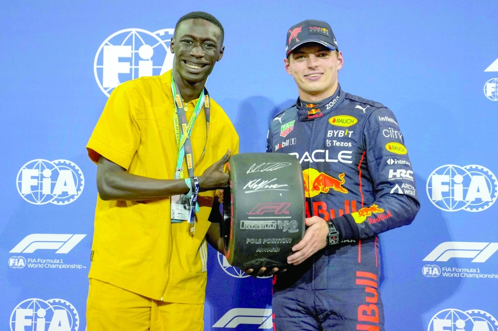 Red Bull's Dutch driver Max Verstappen (R) receives the Pole Position Award after the qualifying session on the eve of the Abu Dhabi Formula One Grand Prix at the Yas Marina Circuit in the Emirati city of Abu Dhabi on November 19, 2022.  (Photo by Kamran JEBREILI / POOL / AFP)

