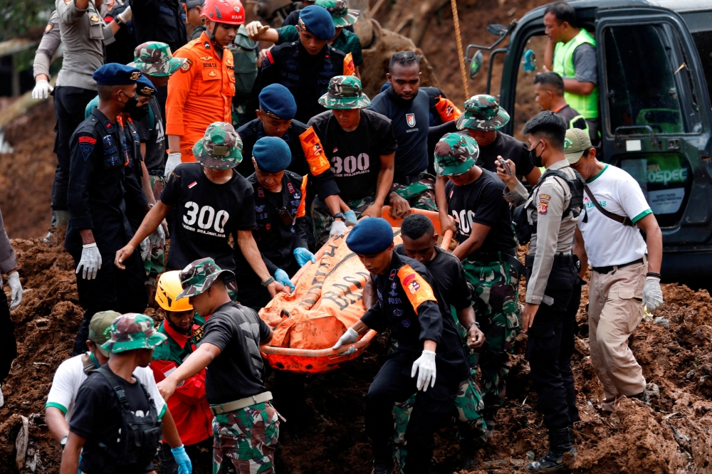 Indonesia rescue members carry a victims body from the site of a landslide caused by the earthquake in Cugenang, Cianjur, West Java province, Indonesia, November 22, 2022.