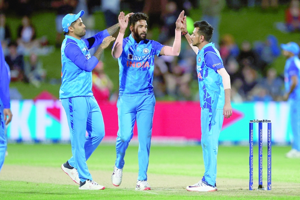 India's Mohammed Siraj (C) celebrates the wicket of New Zealand's Mitchell Santner with teammates Yuzvendra Chahal (R) and Suryakumar Yadav during the third Twenty20 cricket match between New Zealand and India at McLean Park in Napier on November 22, 2022. (Photo by Marty MELVILLE / AFP)

