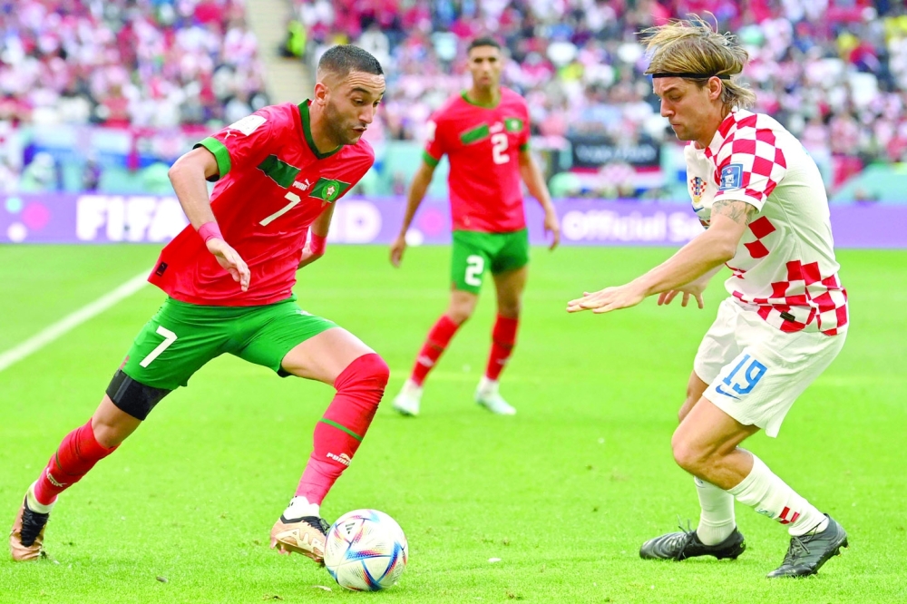 Croatia's defender #19 Borna Sosa (R) fights for the ball with Morocco's midfielder #07 Hakim Ziyech (R) during the Qatar 2022 World Cup Group F football match between Morocco and Croatia at the Al-Bayt Stadium in Al Khor, north of Doha on November 23, 2022. (Photo by Glyn KIRK / AFP)


