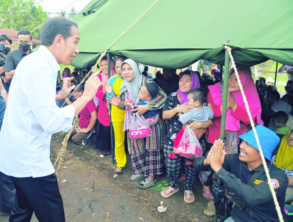 Indonesian President Joko Widodo talks to people who are sheltered at a temporary tent during his visit to the locations affected by the Monday's earthquake in Cianjur, on Thursday. - Reuters