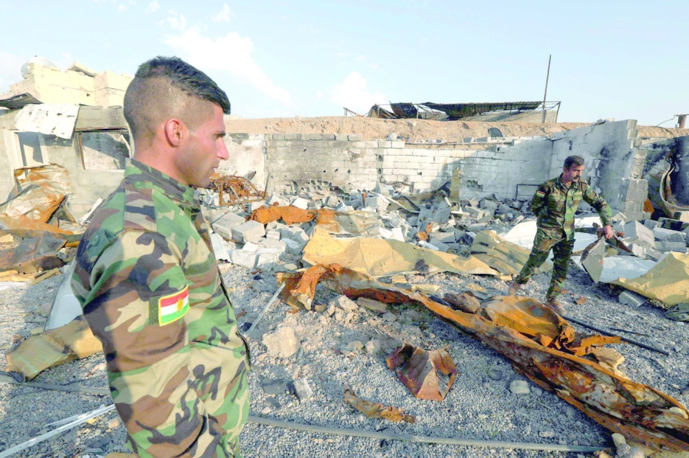 Kurdish fighters assess the destruction caused by a reported Iranian rocket attack near town city of Altun Kupri (Perdi), north of Kirkuk, in Iraq's autonomous Kurdistan region, on Wednesday. — AFP