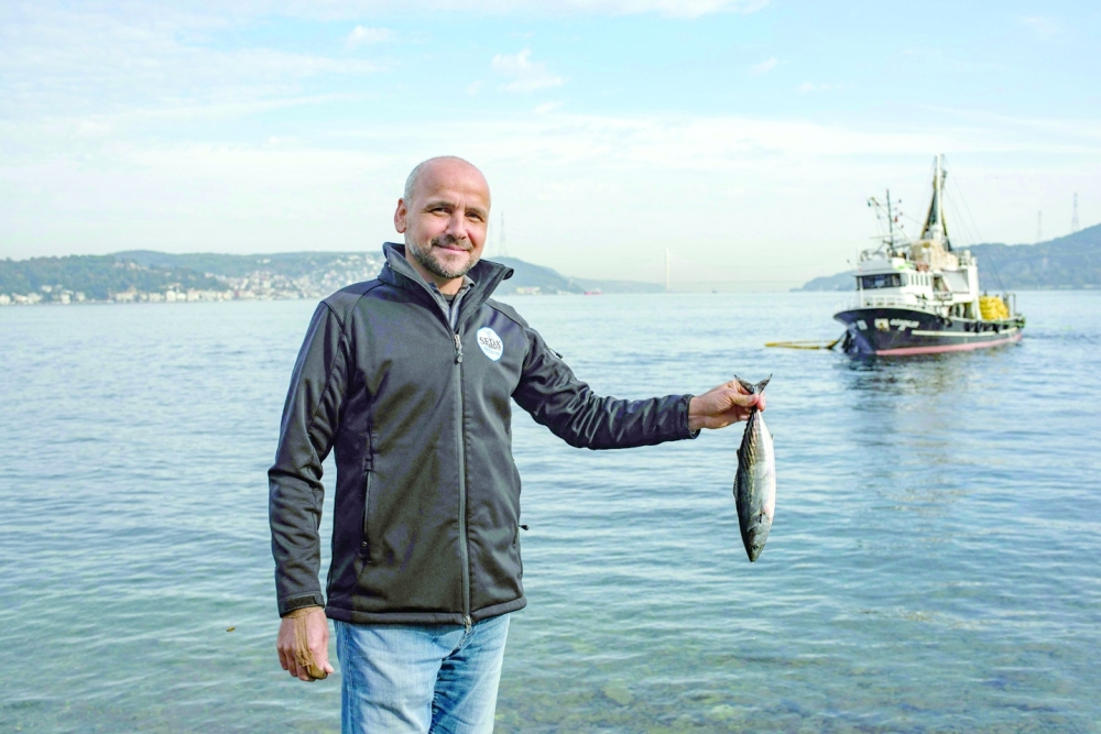Angler Mehmet Dogan poses for a photograph on the bank of the Bosphorus. -- AFP
