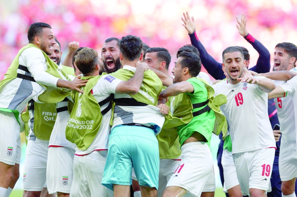 TOPSHOT - Iran's defender #15 Roozbeh Cheshmi (rear C) celebrates scoring his team's first goal during the Qatar 2022 World Cup Group B football match between Wales and Iran at the Ahmad Bin Ali Stadium in Al-Rayyan, west of Doha on November 25, 2022. (Photo by FADEL SENNA / AFP)

