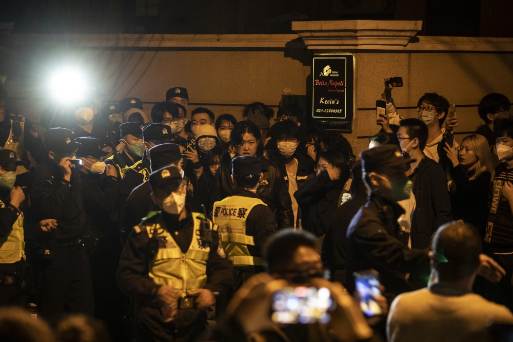 Police officers block Urumqi Road, where protests had taken place the night before, in Urumqi, China, on Sunday, Nov. 27, 2022. (Qilai Shen/The New York Times)