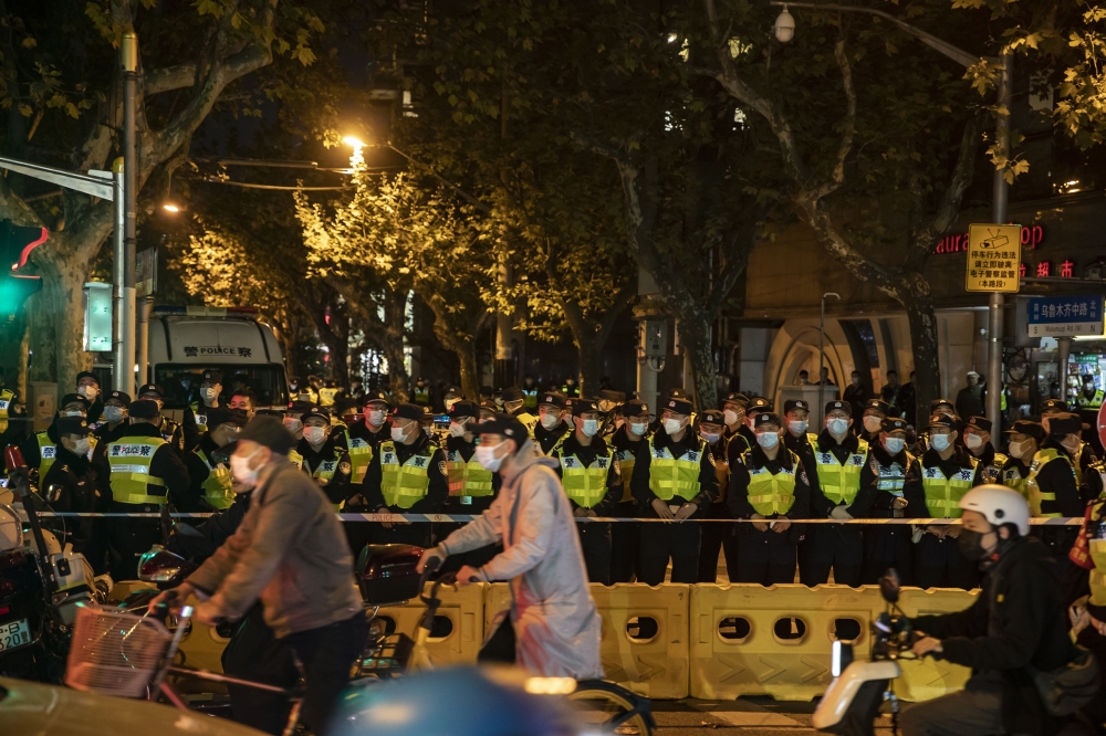 Police officers block Urumqi Road, where protests had taken place the night before, in Urumqi, China, on Sunday, Nov. 27, 2022. (Qilai Shen/The New York Times)