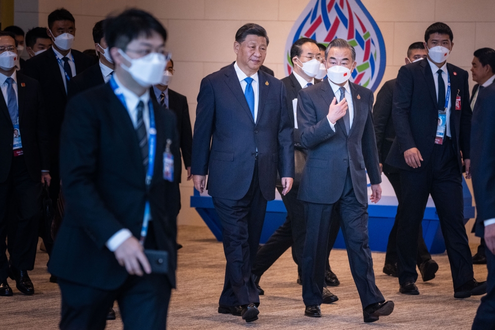 President Xi Jinping of China, center, confers with Foreign Minister Wang Yi as they arrived at the Asia-Pacific Economic Cooperation summit site in Bangkok, Nov. 19, 2022. (Haiyun Jiang/The New York Times)