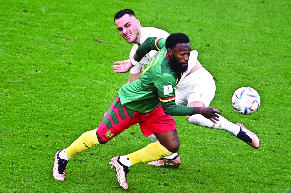 TOPSHOT - Cameroon's midfielder #07 Georges-Kevin Nkoudou (Front) fights for the ball with Serbia's midfielder #17 Filip Kostic during the Qatar 2022 World Cup Group G football match between Cameroon and Serbia at the Al-Janoub Stadium in Al-Wakrah, south of Doha on November 28, 2022. (Photo by Anne-Christine POUJOULAT / AFP)

