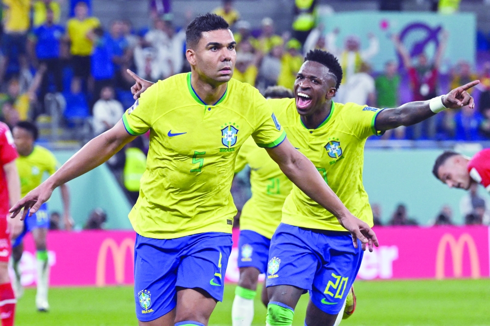 Brazil's midfielder #05 Casemiro (L) celebrates with Brazil's forward #20 Vinicius Junior after he scored his team's first goal during the Qatar 2022 World Cup Group G football match between Brazil and Switzerland at Stadium 974 in Doha on November 28, 2022. (Photo by NELSON ALMEIDA / AFP)

