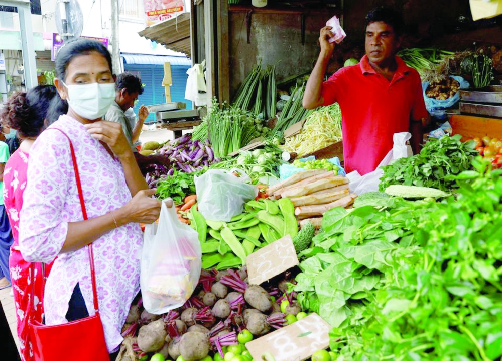A vendor sells vegetables to a customer in Colombo, Sri Lanka. — Reuters