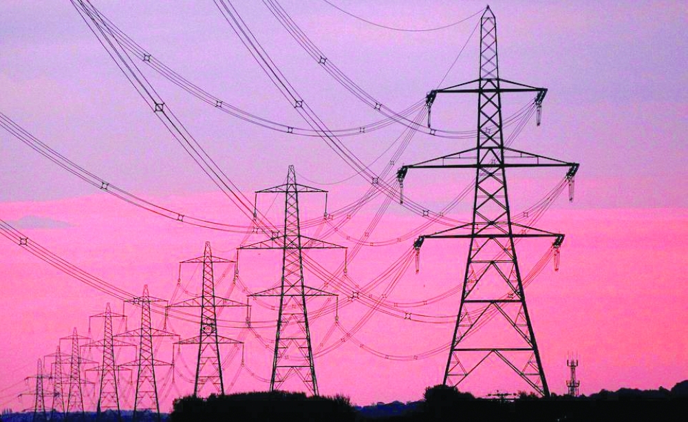 The sun rises behind electricity pylons near Chester, northern England. — Reuters