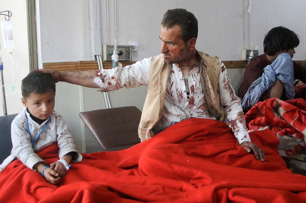 A father and son receive medical aid in hospital after being wounded in a suicide bomb blast on a police patrol in Quetta