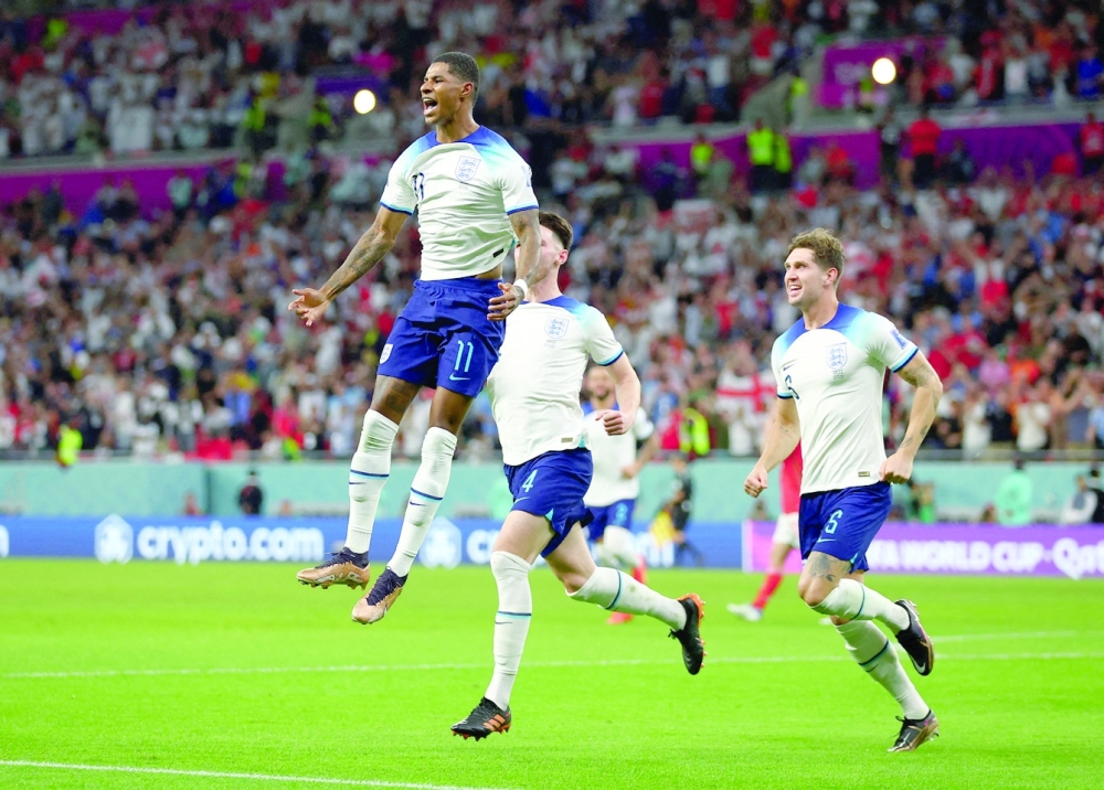 Soccer Football - FIFA World Cup Qatar 2022 - Group B - Wales v England - Ahmad Bin Ali Stadium, Al Rayyan, Qatar - November 29, 2022 England's Marcus Rashford celebrates scoring their first goal with Declan Rice and John Stones REUTERS/Hannah Mckay     TPX IMAGES OF THE DAY