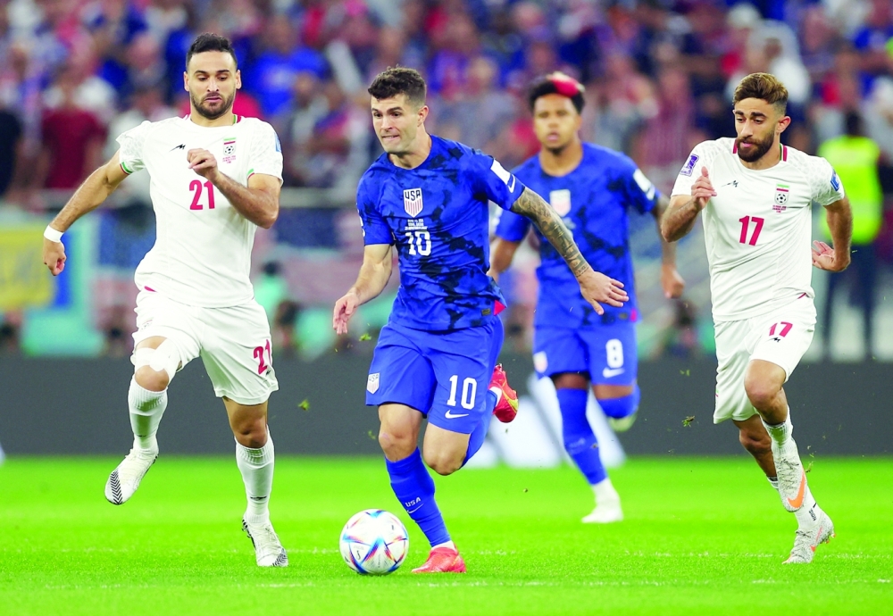 Soccer Football - FIFA World Cup Qatar 2022 - Group B - Iran v United States - Al Thumama Stadium, Doha, Qatar - November 29, 2022 Christian Pulisic of the U.S. in action with Iran's Ahmad Noorollahi REUTERS/Kai Pfaffenbach
