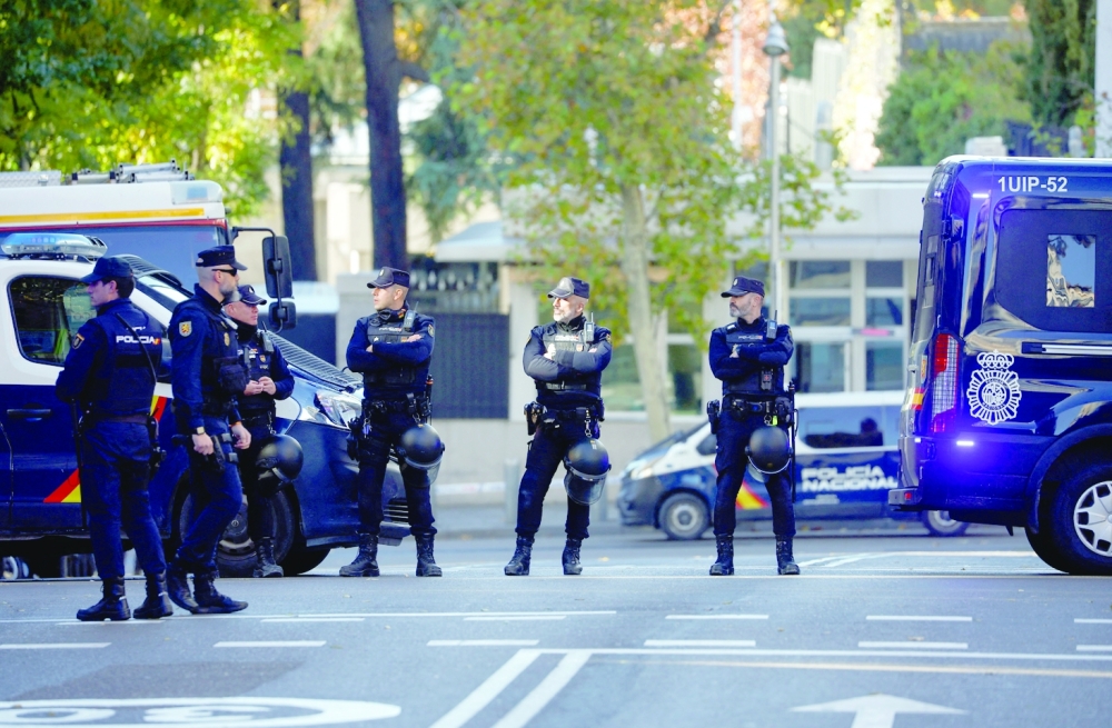 Police officers stand outside the US Embassy in Madrid after a suspected explosive device hidden in an envelope was mailed to the embassy. -- Reuters