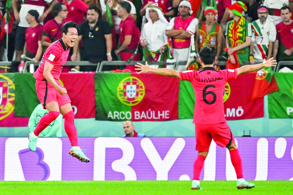 TOPSHOT - South Korea's defender #19 Kim Young-gwon (L) celebrates with teammates after scoring his team's first goal during the Qatar 2022 World Cup Group H football match between South Korea and Portugal at the Education City Stadium in Al-Rayyan, west of Doha on December 2, 2022. (Photo by JUNG Yeon-je / AFP)

