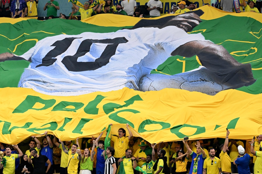 A large flag of Brazil legend Pele is unveiled in the crowd ahead of the Qatar 2022 World Cup Group G football match between Cameroon and Brazil at the Lusail Stadium in Lusail, north of Doha on December 2, 2022. 