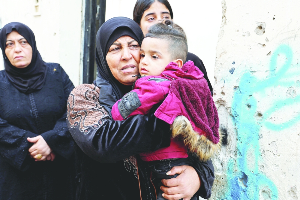 The mother and son of Tareq al Damej a Palestinian who was killed by Israeli forces during clashes in a raid, attend his funeral, in Jenin, in West Bank. - Reuters