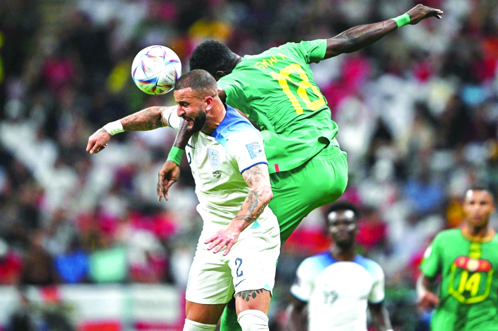 England's Kyle Walker and Senegal's Ismaila Sarr jump for a header during the Qatar 2022 World Cup match. — AFP